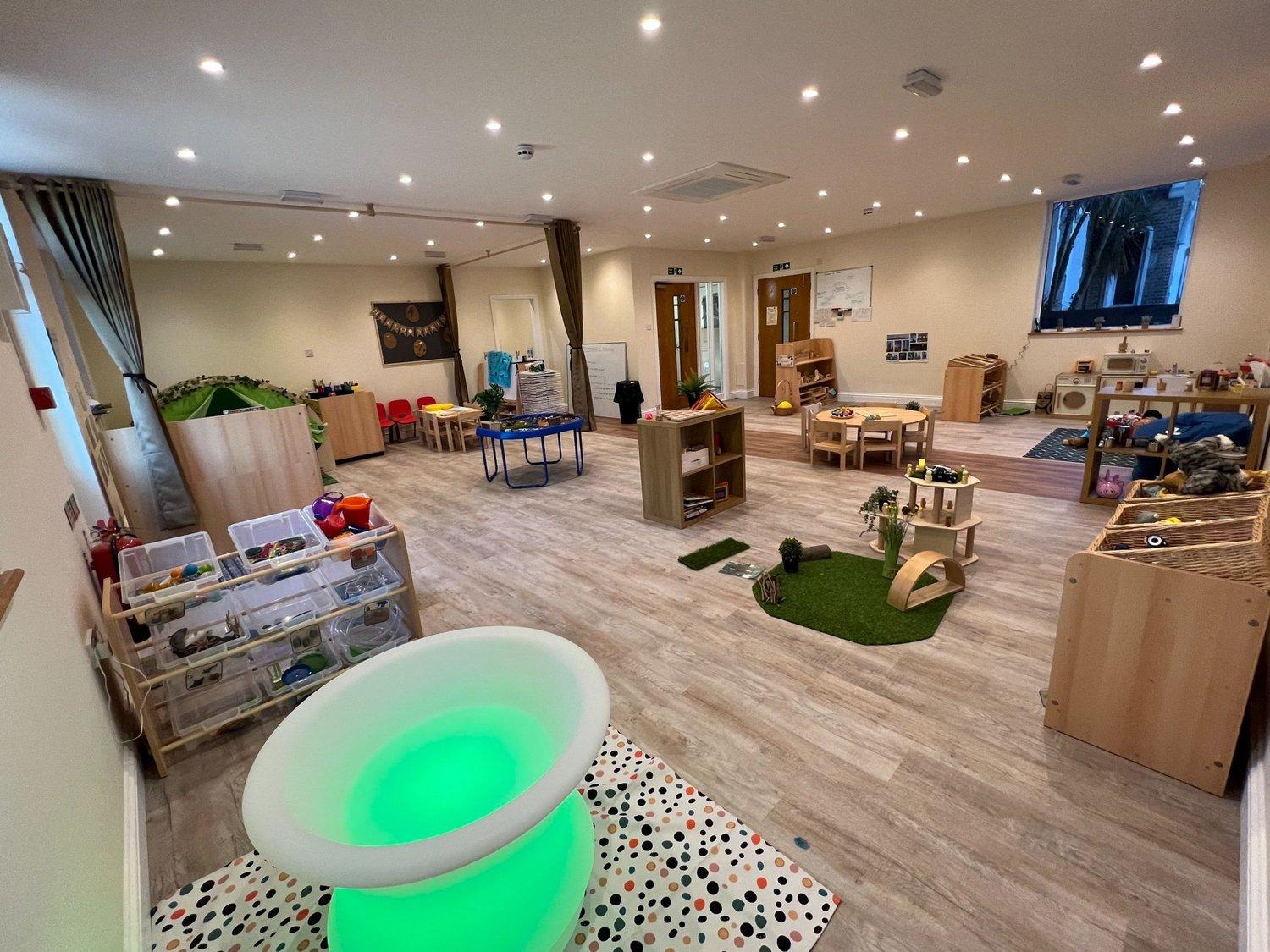 A spacious preschool learning room with books and activity zones