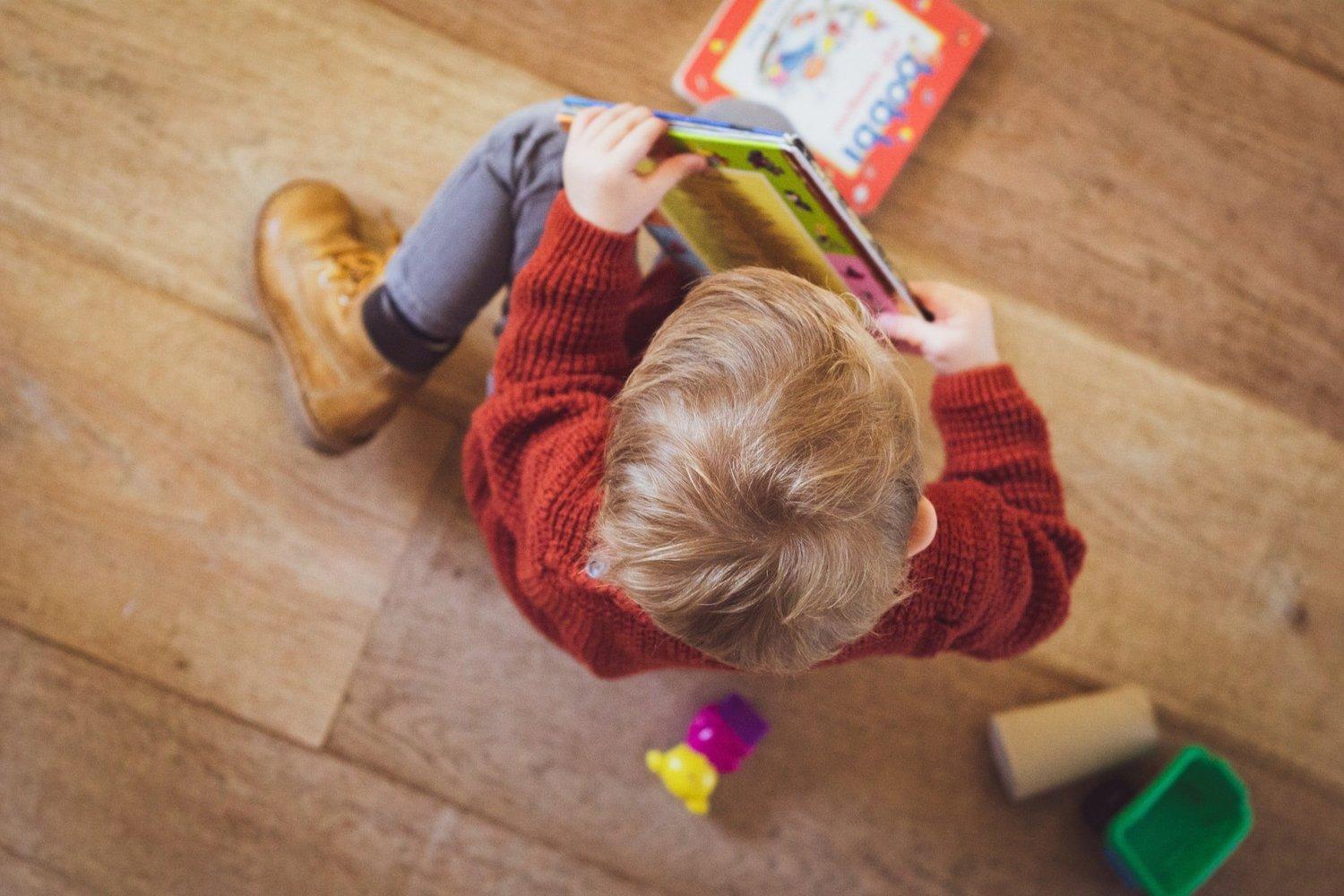 A preschool child reading a picture book independently