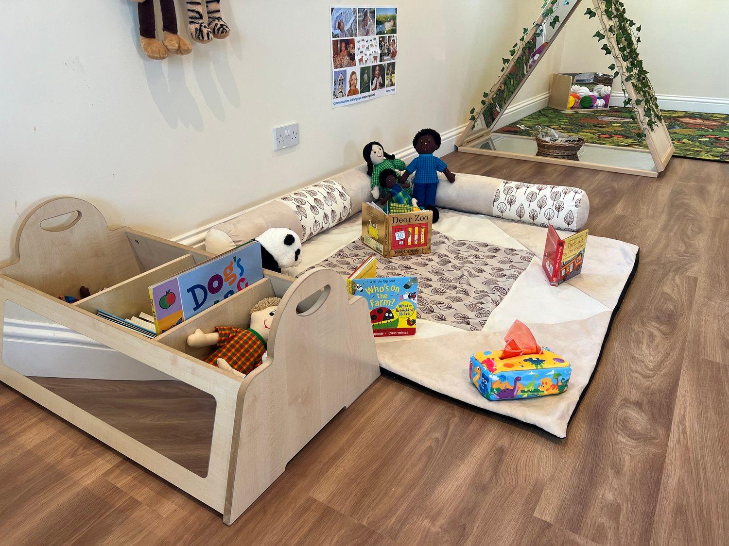 A calm nursery area offering books, sensory resources, and a quiet place to settle