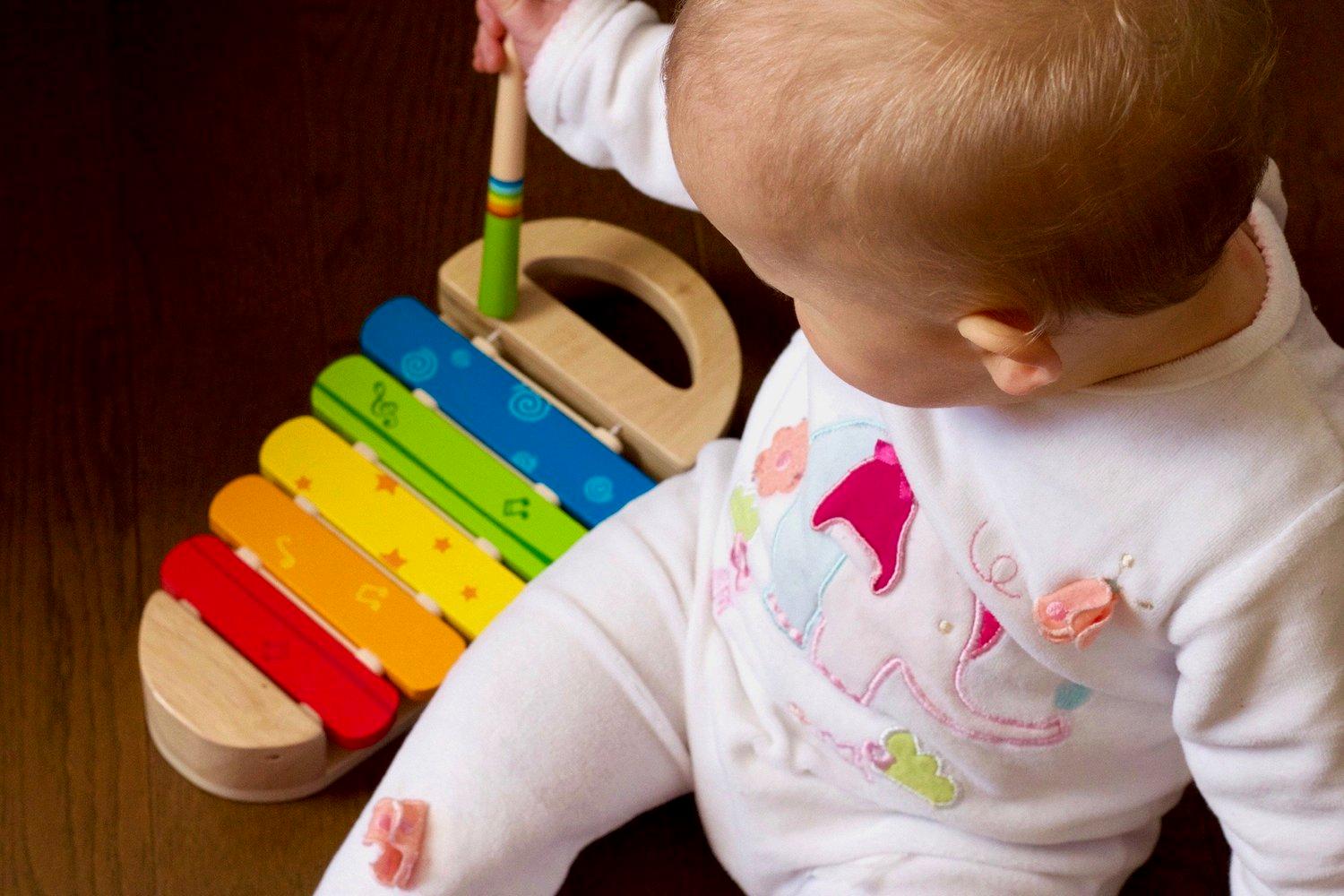A young child absorbed in a familiar musical activity