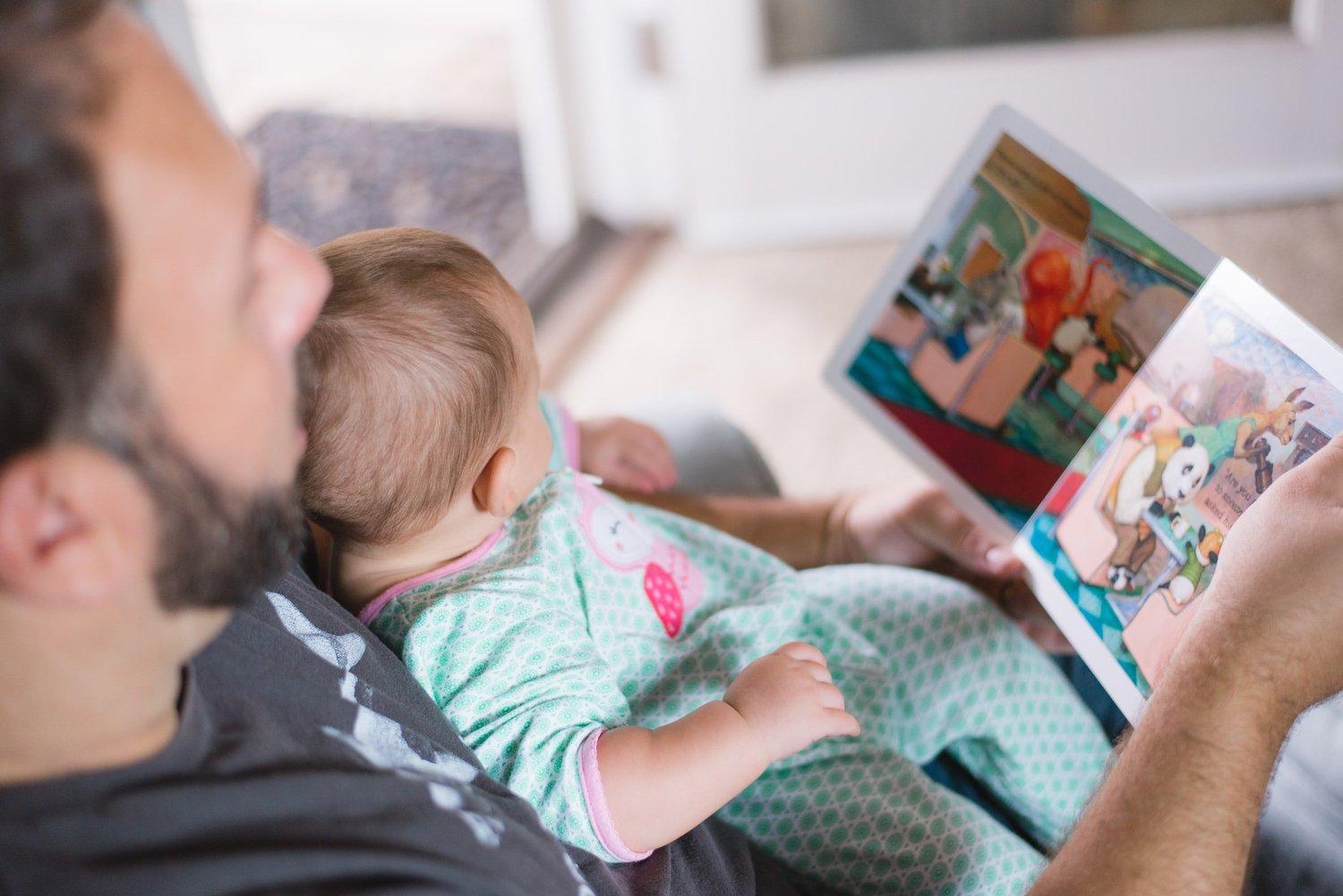 A parent and young child sharing a book before starting nursery